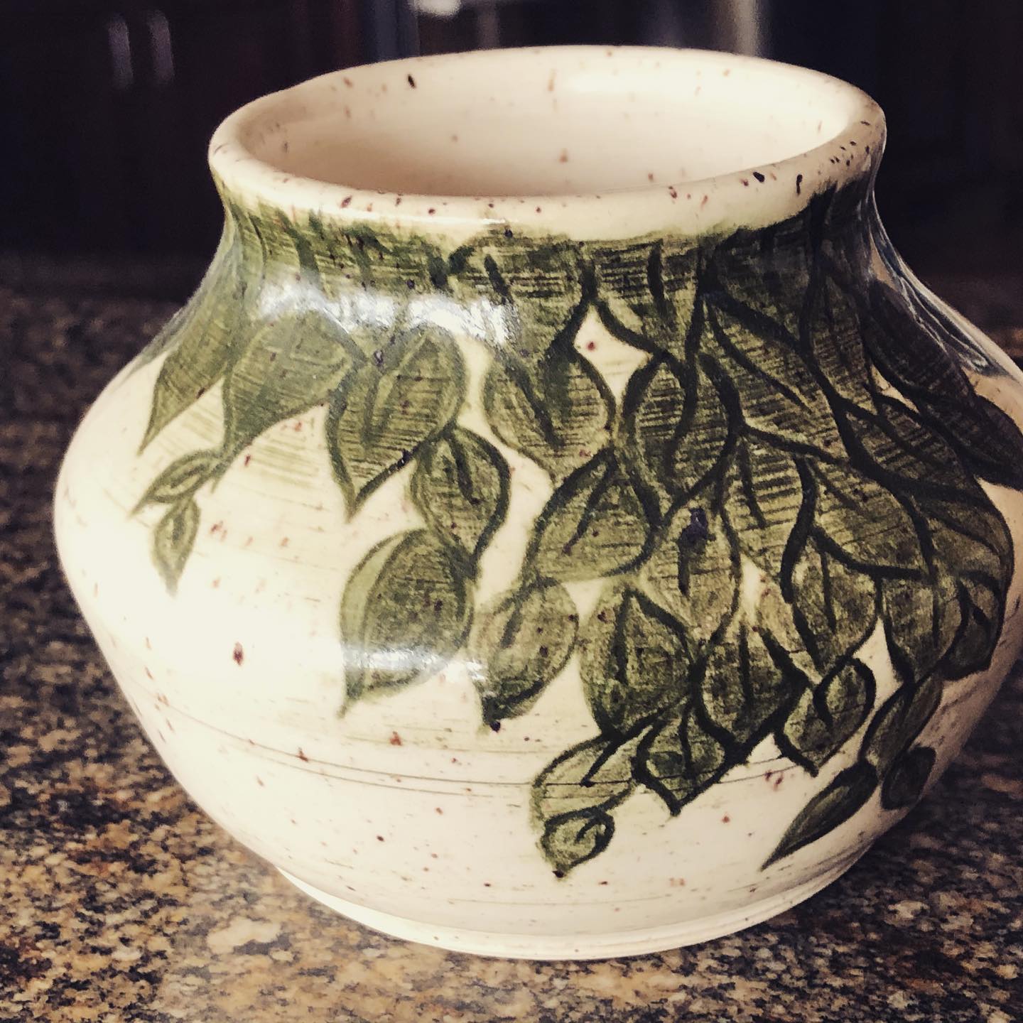 Botanical pottery vase with green leaves